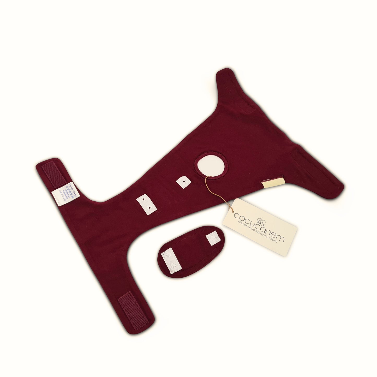 Detailansicht des Innenlebens der Läufigkeitshose Lexie, die hier flach und offen daliegt. Das Paddie liegt daneben und zeigt die Unterseite mit ihren Druckknöpfen. Die Gegendruckknöpfe sind an der passenden Stelle unterhalb des Rutenlochs an der Hose angebracht.