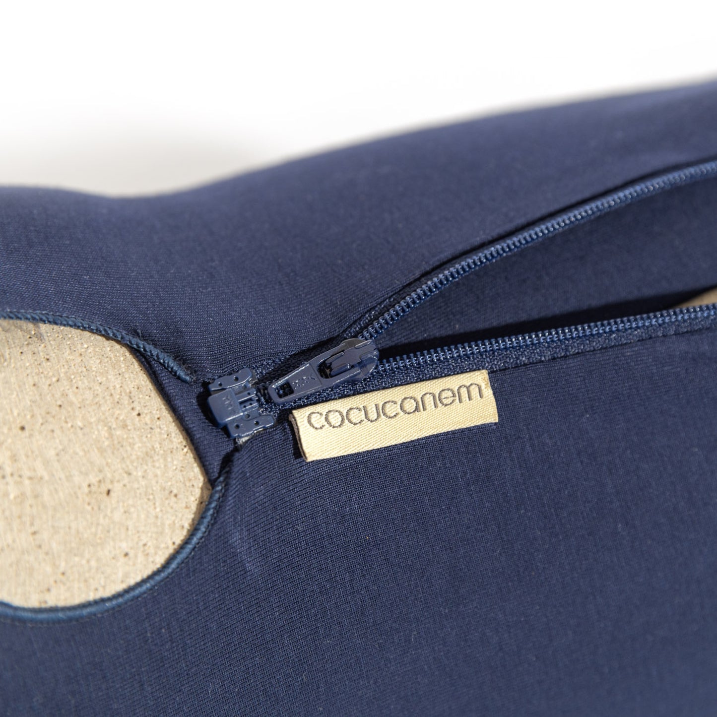 Die Detailaufnahme vom marineblauen cocucanem Hundebody zeigt den halb geöffneten, teilbaren Reißverschluss, der versetzt unterhalb der Wirbelsäule verläuft und mit einem Untertritt unterlegt ist, damit kein Fell eingeklemmt wird.